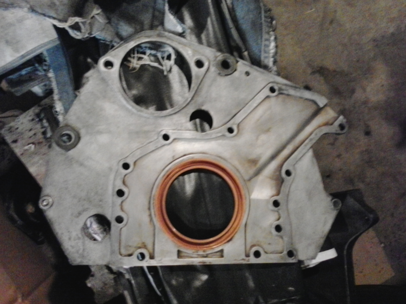 Block side of rear plate. This plate houses the rear main seal, provides an oil drainback channel from the cylinder head, and gives the starter something to bolt to.